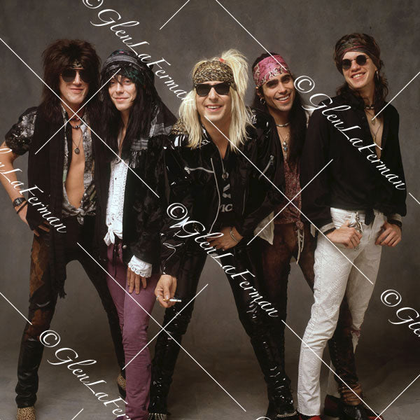 Faster Pussycat in a group, leaning forward with cigarette, smiling