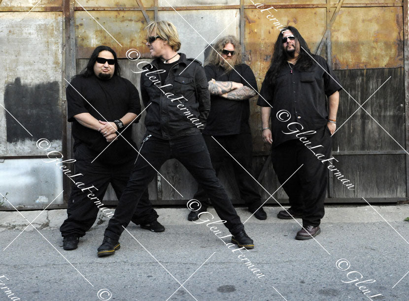 Fear Factory in all black with sunglasses, wide stance