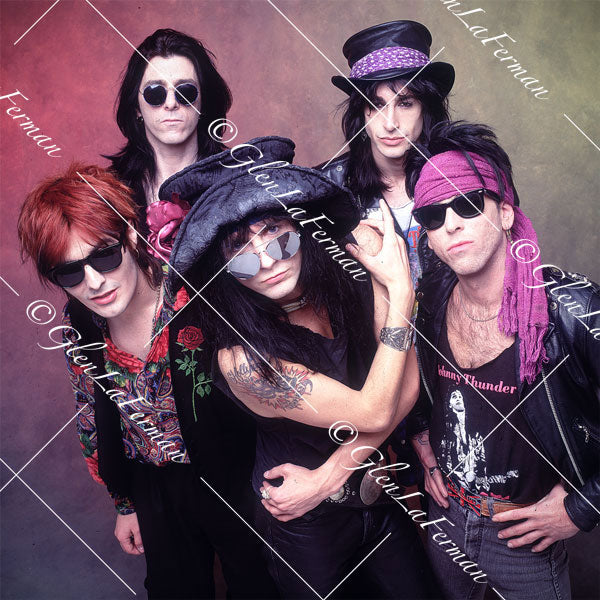 L.A. Guns close up, arms crossed, colorful drop