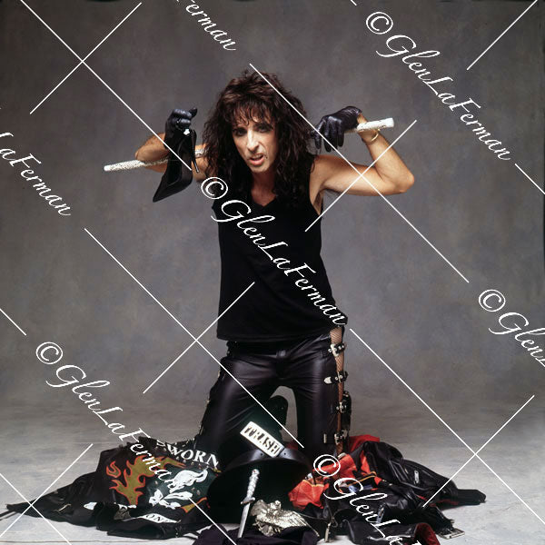 Alice Cooper kneeling with baton