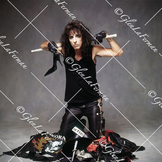 Alice Cooper kneeling with baton and stiletto