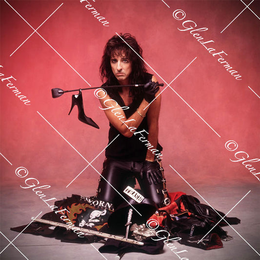 Alice Cooper in sleeveless shirt holding a club and stiletto