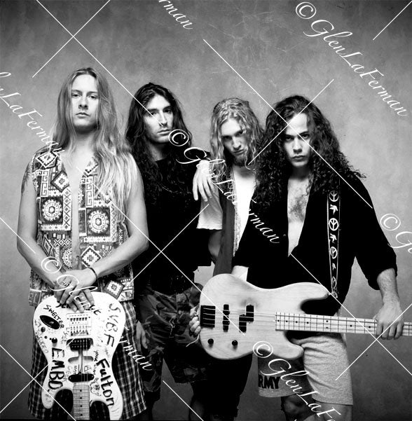 Alice in Chains holding guitars, leaning shoulder to shoulder