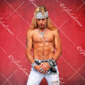 Brett Michaels standing shirtless looking down with red drop