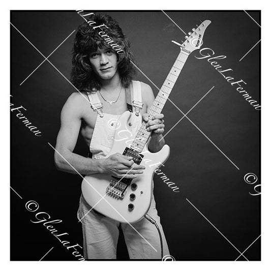 A Print and Photograph of Eddie Van Halen in overalls strumming his guitar