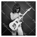 A Print and Photograph of Eddie Van Halen in overalls looking at guitar