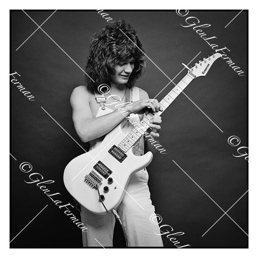 A Print and Photograph of Eddie Van Halen in overalls looking at guitar