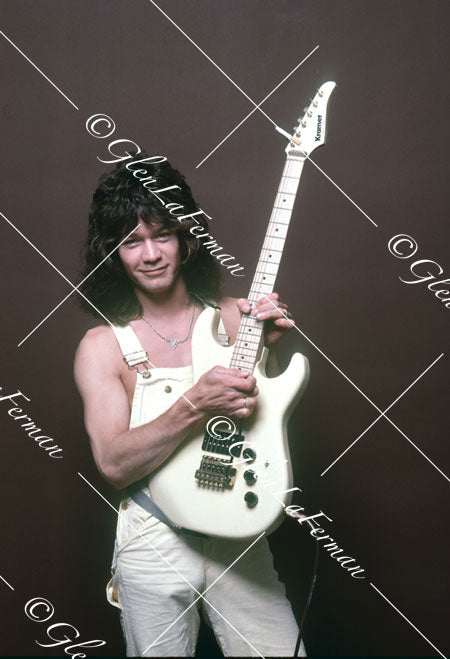 A Print and Photograph of Eddie Van Halen in overalls strumming Kramer Frankenstrat