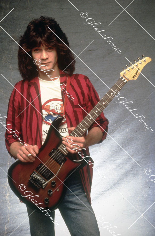 Eddie Van Halen in blazer standing holding Kramer Frankenstrat