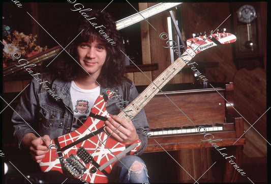 Eddie Van Halen smiling in home studio by piano with Kramer Frankenstrat