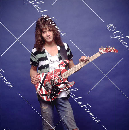 Eddie Van Halen in jeans looking at camera with Kramer Frankenstrat