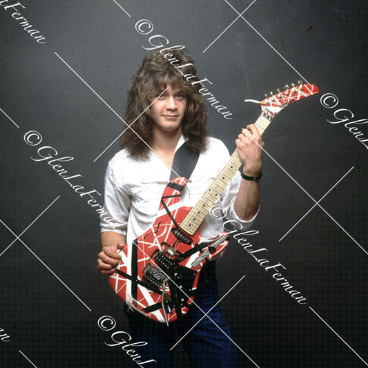 Eddie Van Halen in white button up shirt looking at camera with Kramer Frankenstrat