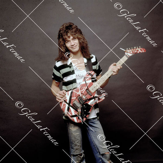 Eddie Van Halen in striped shirt and Kramer Frankenstrat with grey backdrop