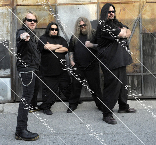 Fear Factory in all black with sunglasses, pointing