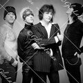 L.A. Guns close up, arms crossed, pinstriped suit