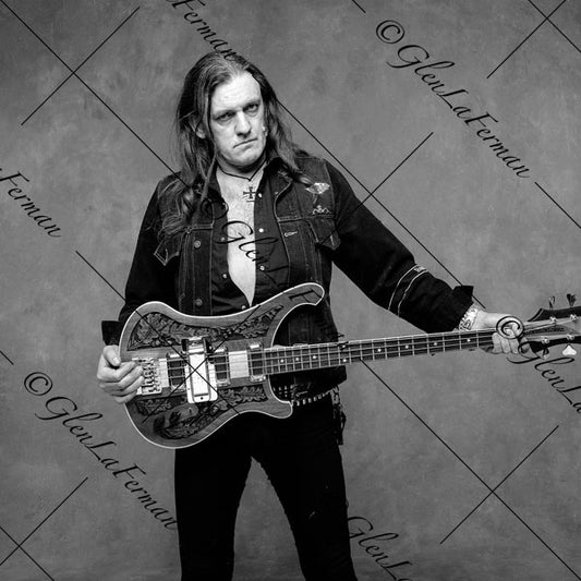 Lemmy Kilmister holding guitar in jean jacket