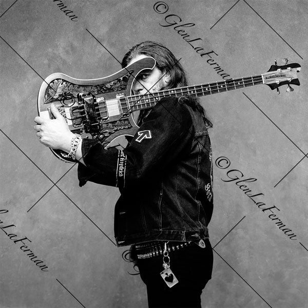 Lemmy Kilmister holding guitar at face, profile