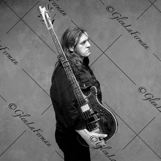 Lemmy Kilmister cradling guitar, looking out