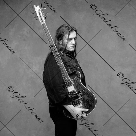 Lemmy Kilmister holding guitar, looking back