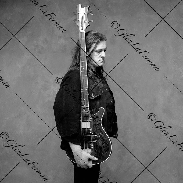 Lemmy Kilmister holding guitar, looking downward