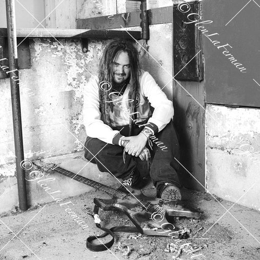 Max Cavalera siiting with guitar, smiling