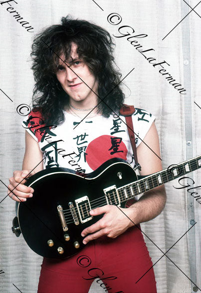 Vivian Campbell in red standing with Les Paul