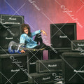Vivian Campbell in studio leaning back on amps, smiling