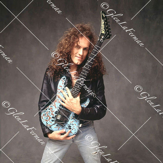 Vivian Campbell in leather jacket holding Kramer Frankenstrat