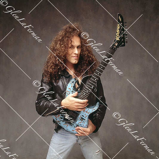 Vivian Campbell in leather jacket holding blue Kramer Frankenstrat